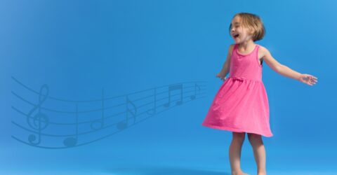 petite fille qui danse devant un fond bleu