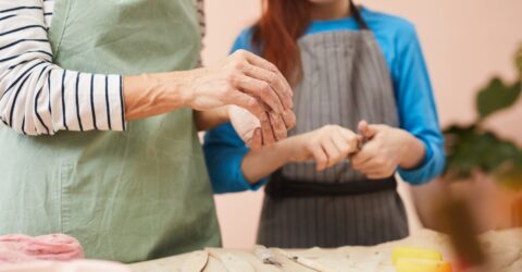 un adulte et une enfant en train de manipuler de l'argile