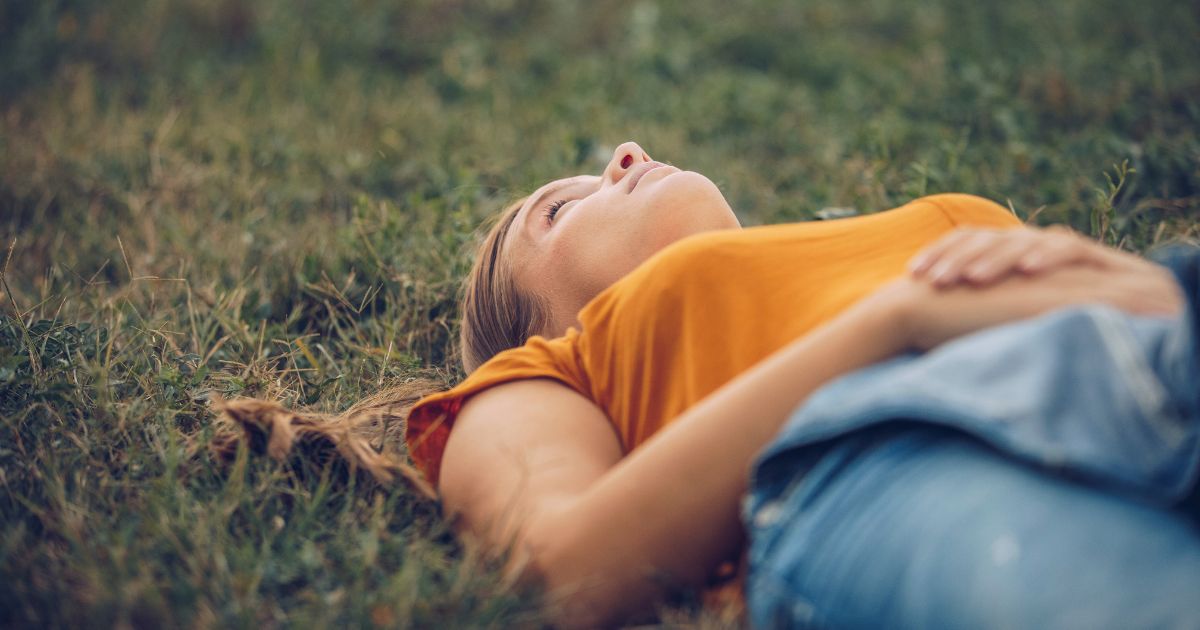 jeune femme allongée dans l'herbe