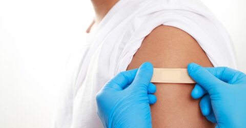 médecin en train de positionner un pansement après un vaccin